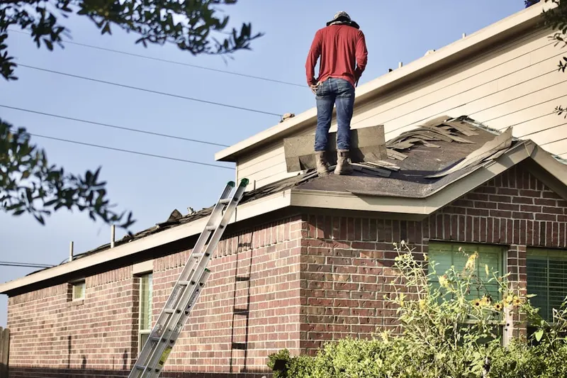 Professional roofer working on a residential roof in Volo